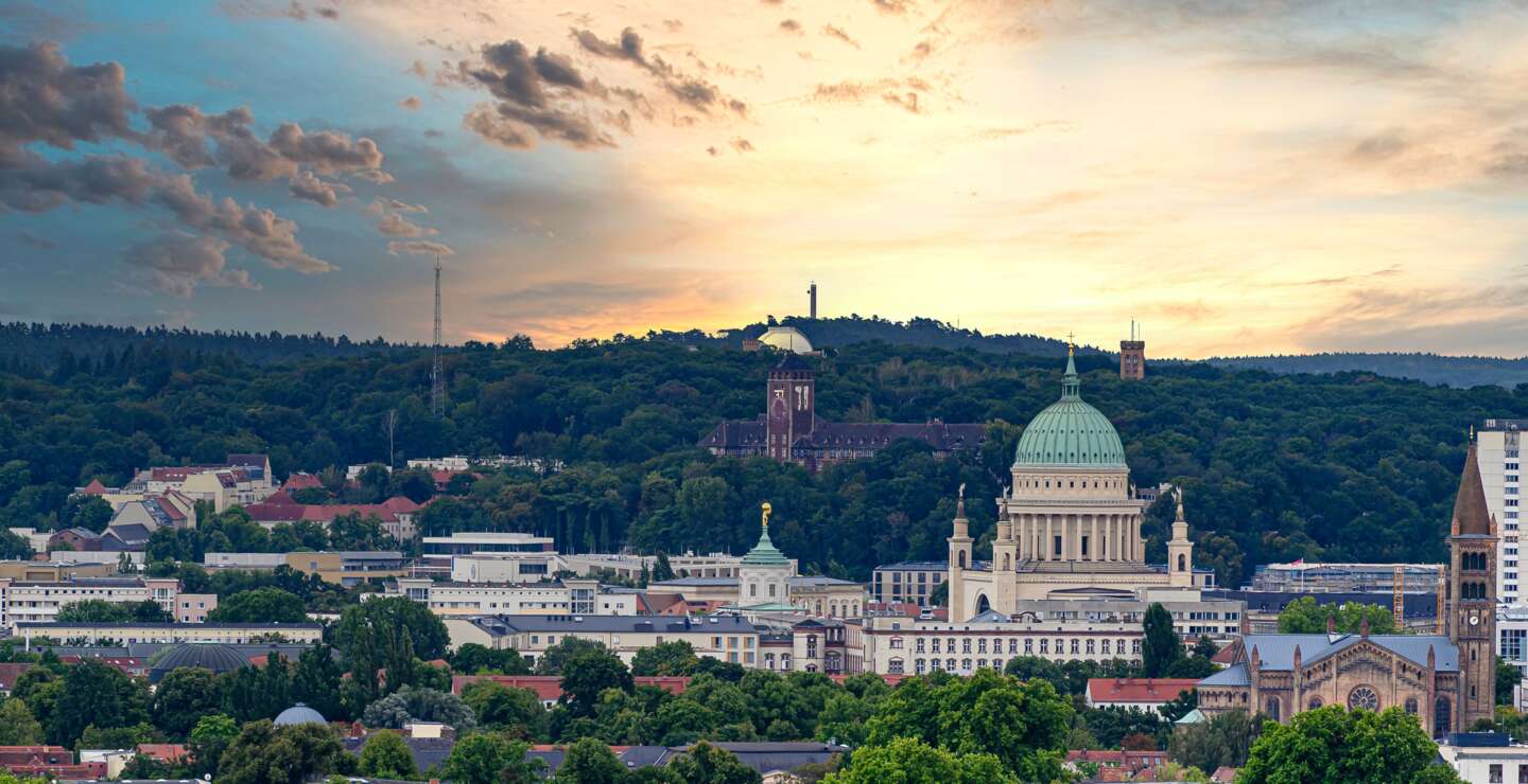 Potsdam bei Sonnenauf- oder -untergang mit Nikolaikirche und gruener Stadtlandschaft